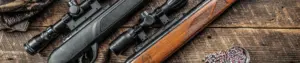 Gamo air rifles, scopes and pellets arranged on a wooden surface
